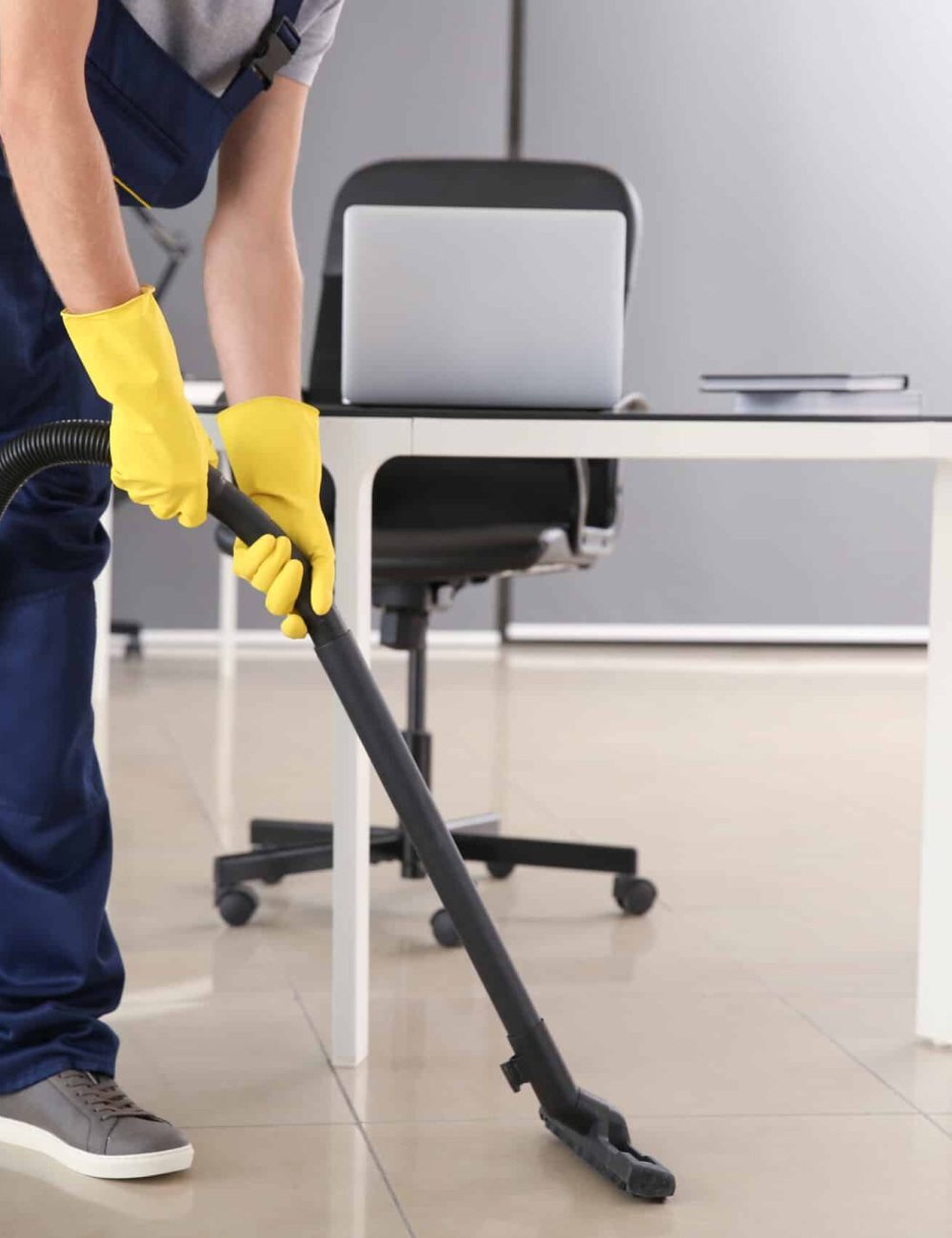 Janitor hoovering floor in office